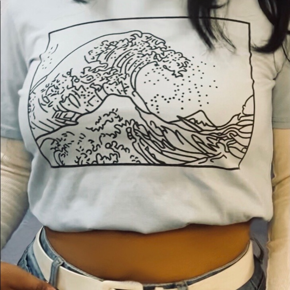 Cotton light blue shirt with wave design on front.